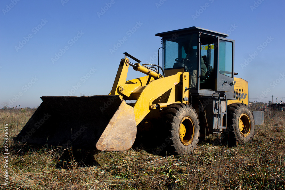 Yellow rusty Bulldozer at work in the field Yellow rusty Bulldozer at work in the field