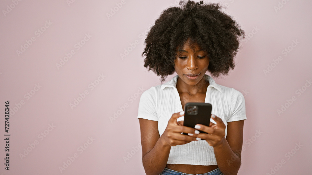 African american woman using smartphone with serious expression over isolated pink background African american woman using smartphone with serious expression over isolated pink background