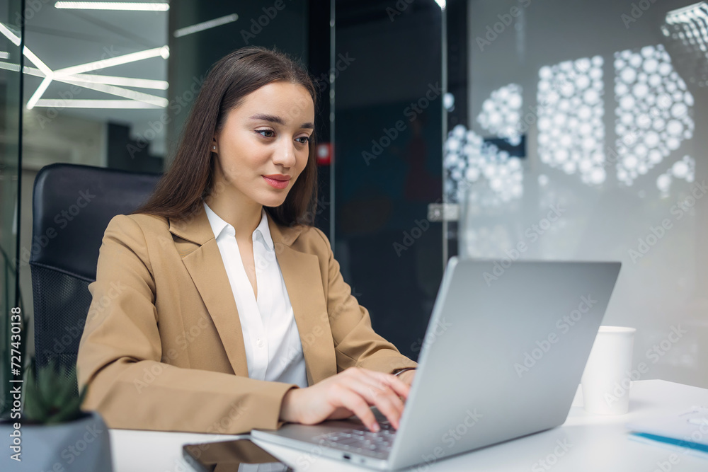 Joyful girl smiling look at laptop at office, working remotely, discussing a new project online