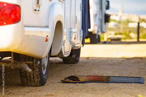 Flip flops on wiper in front of camper car