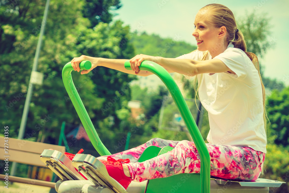Obraz premium Girl doing legs exercise at outdoor gym area