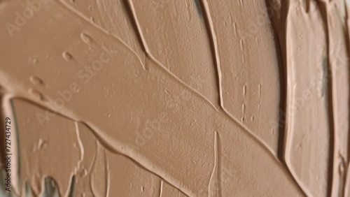 Vertical video. Macro video shooting of cosmetic cream. Beige texture. View from above