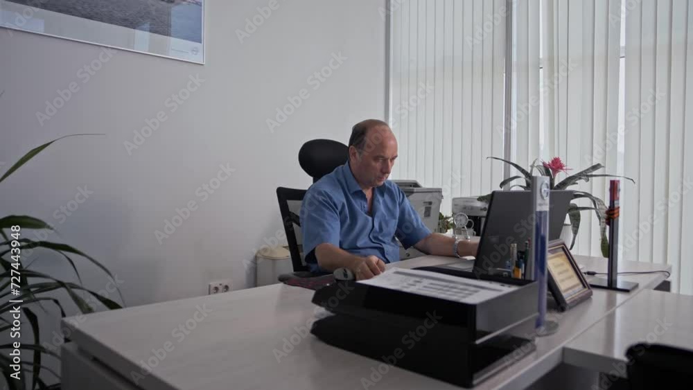 Mature senior sales manager works on a laptop Mature senior sales manager works on a laptop