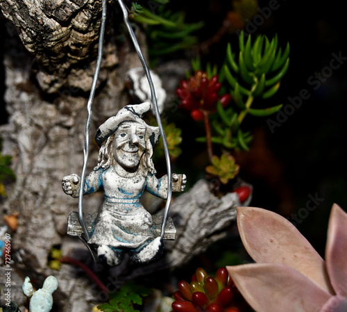 Fototapeta Naklejka Na Ścianę i Meble -  A little gray witch riding a swing