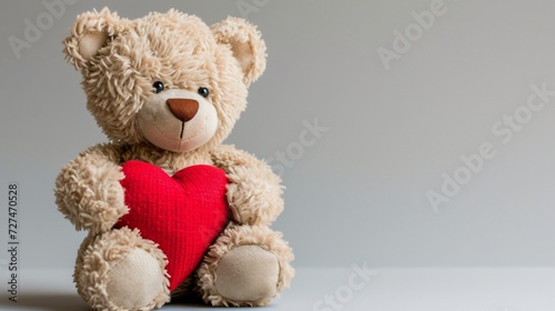 Valentines day teddy bear holding red heart on grey background