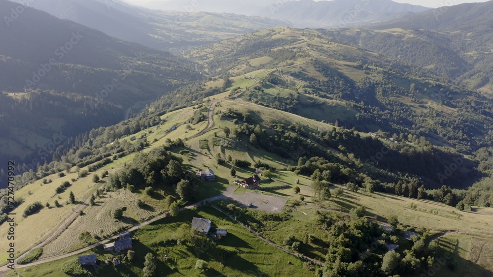 Sunny Summer Aerial Panorama of Verdant Carpathian Mountain Landscape, Highlighting Rolling Hills and Rural Settlements