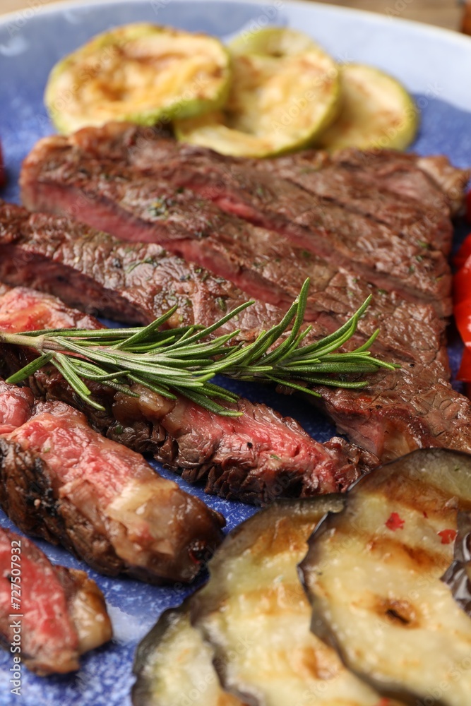 Delicious grilled beef with vegetables and rosemary on plate, closeup