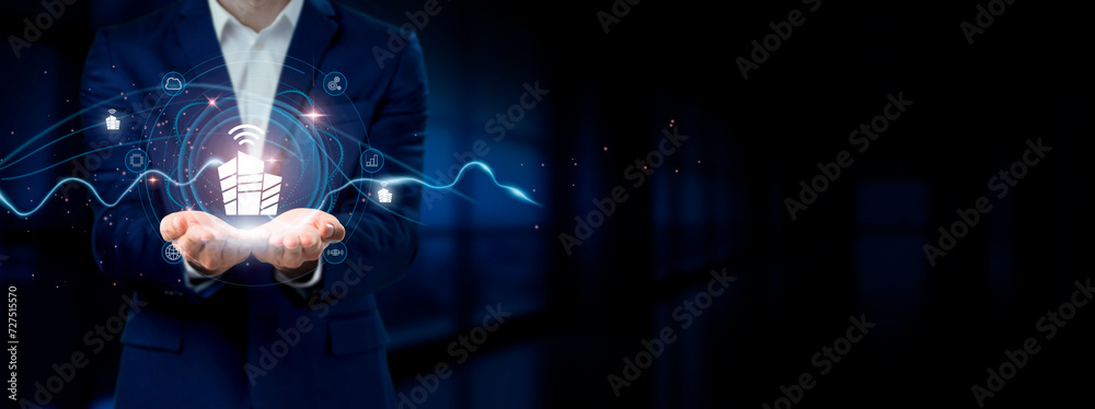 Fototapeta premium Businessman holding virtual Smart Home network connection icons. Automation, Connectivity, Innovation in Internet business and social network.