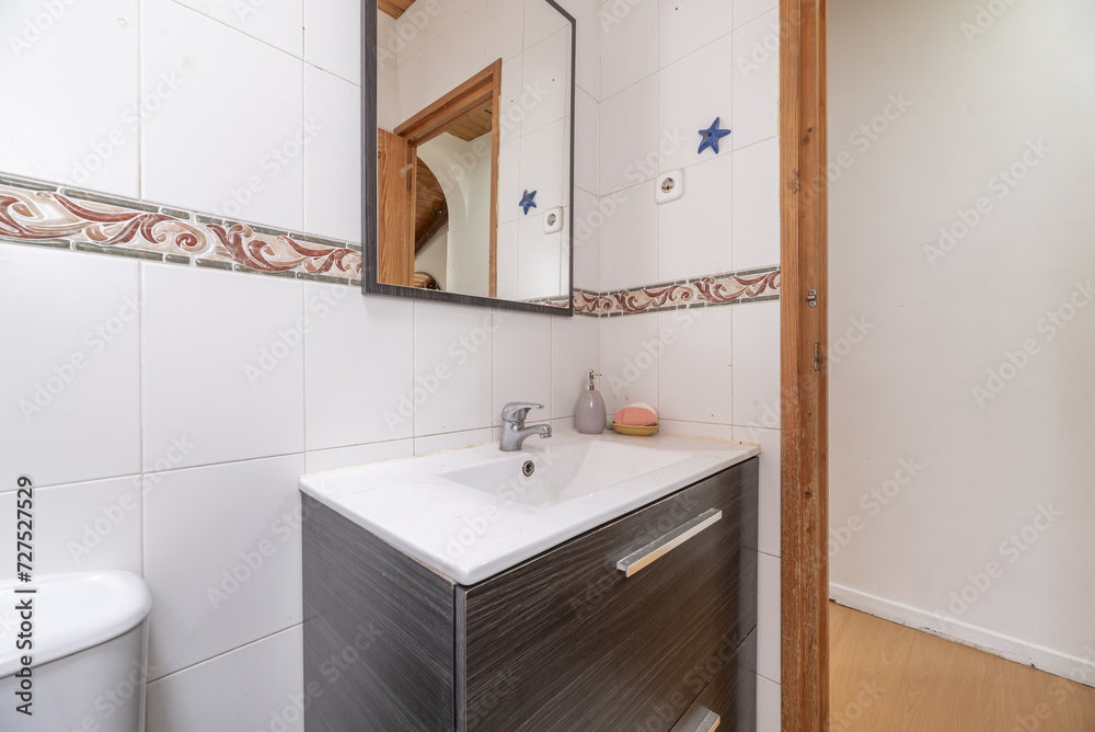 A small bathroom with white porcelain toilets on dark wood furniture A small bathroom with white porcelain toilets on dark wood furniture
