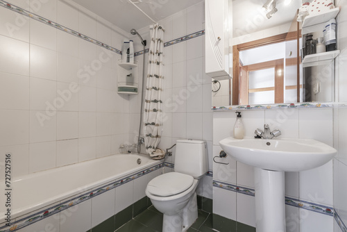 A small bathroom with white porcelain toilets  a framed mirror