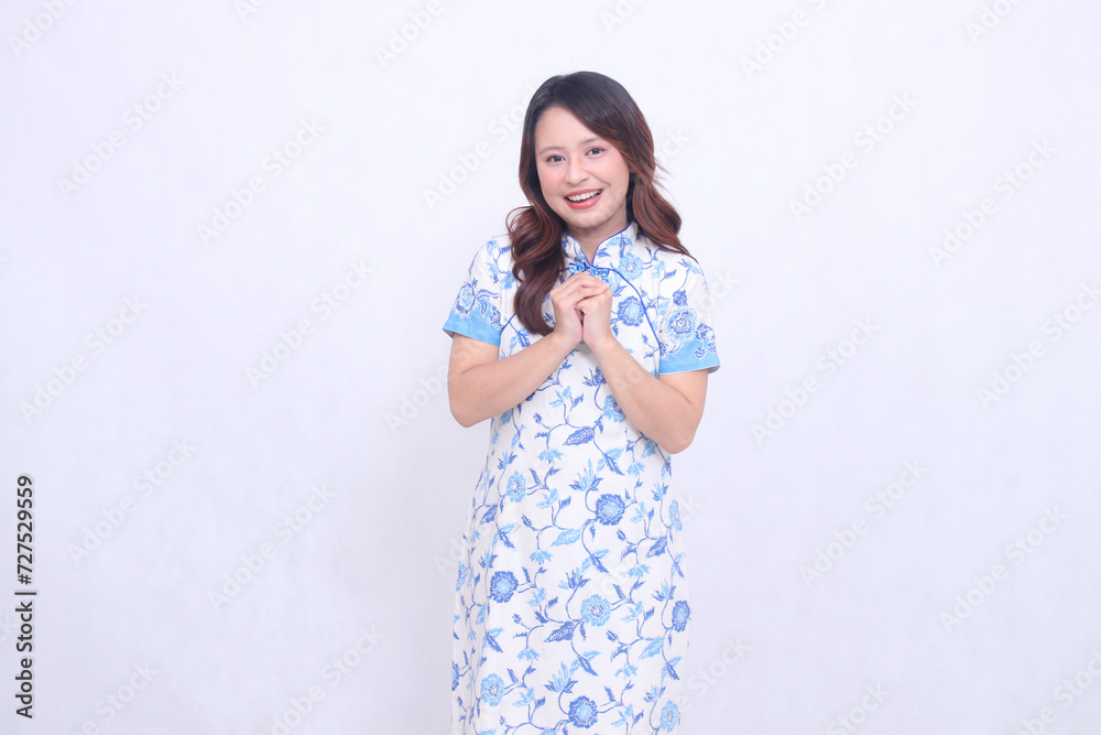 Beautiful indonesian woman laughing wearing modern chinese dress hand signed formal chinese greeting isolated on white background. happy Chinese New Year Beautiful indonesian woman laughing wearing modern chinese dress hand signed formal chinese greeting isolated on white background. happy Chinese New Year