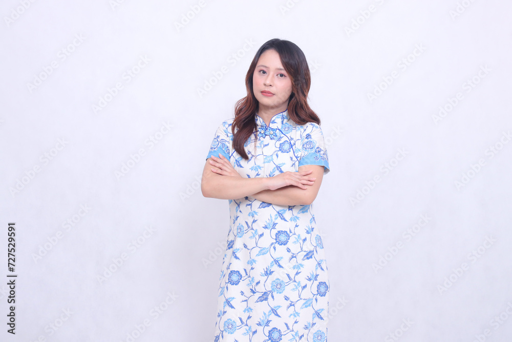 Beautiful indonesian girl smile wearing modern chinese dress arms crossed isolated on white background. happy Chinese New Year Beautiful indonesian girl smile wearing modern chinese dress arms crossed isolated on white background. happy Chinese New Year