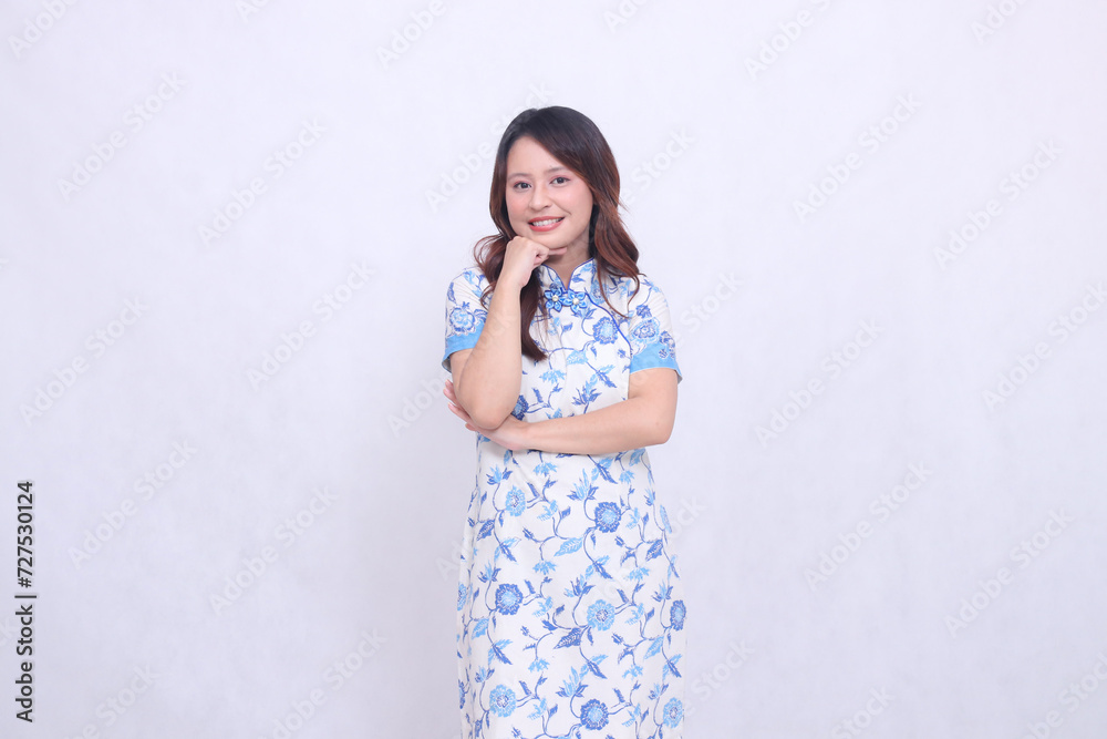 Beautiful smiling asian woman wearing modern chinese dress arms folded on chin isolated on white background. happy Chinese New Year Beautiful smiling asian woman wearing modern chinese dress arms folded on chin isolated on white background. happy Chinese New Year