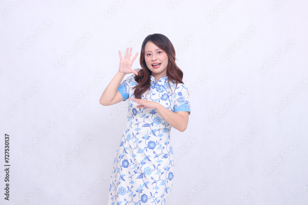 beautiful cheerful asian girl wearing modern chinese dress arms crossed saying hello isolated on white background. happy Chinese New Year beautiful cheerful asian girl wearing modern chinese dress arms crossed saying hello isolated on white background. happy Chinese New Year