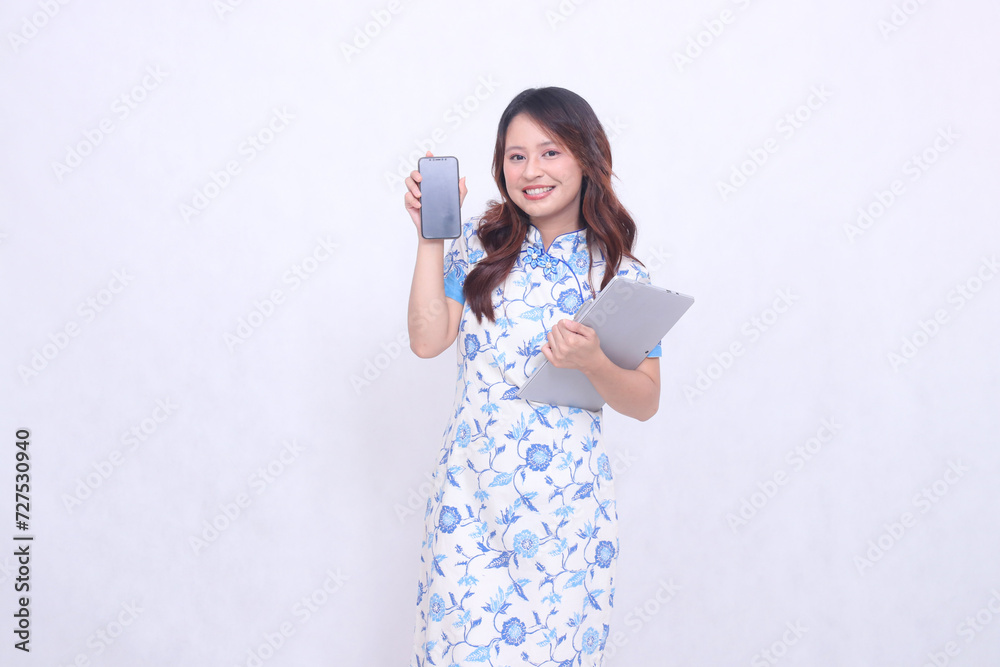 beautiful asian woman wearing blue chinese dress front view cheerful holding tablet and looking at cell phone screen isolated white background beautiful asian woman wearing blue chinese dress front view cheerful holding tablet and looking at cell phone screen isolated white background