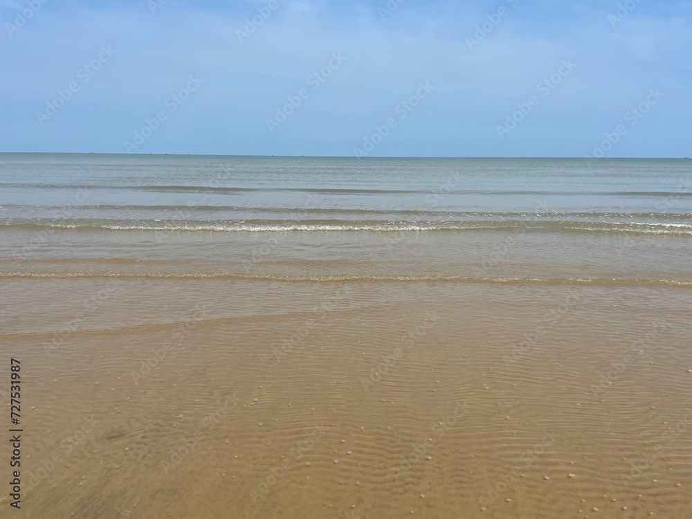View of a sandy beach during the day with a blue sky background. clear sea water. vintage color beach
View of a sandy beach during the day with a blue sky background. clear sea water. vintage color beach