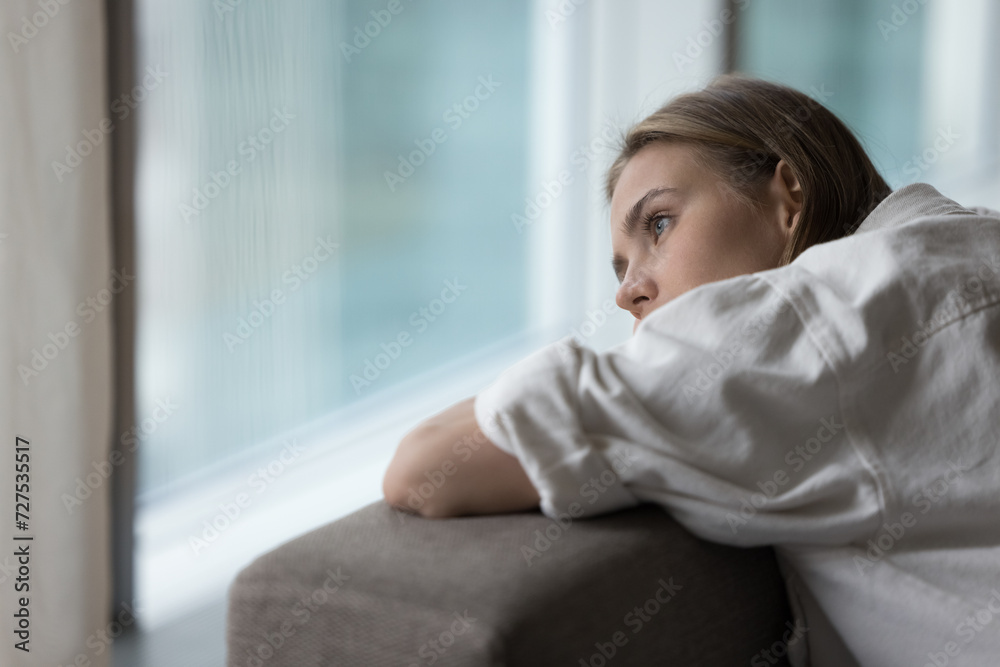 Lonely young woman lies on sofa, looking out window, having melancholic mood, suffer of unrequited love, break up, feel depressed, unhappy alone at home, pensive attractive female thinks about problem Lonely young woman lies on sofa, looking out window, having melancholic mood, suffer of unrequited love, break up, feel depressed, unhappy alone at home, pensive attractive female thinks about problem