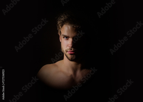 Sexy man studio portrait. Psychological male portrait. Art portrait in a dark key of a handsome sexy serious young man with sexy body looks in camera. Male face. Handsome confident stylish sexy model.