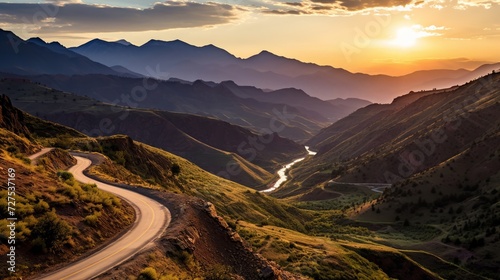 A scenic route winding through mountains as the sun sets in splendor