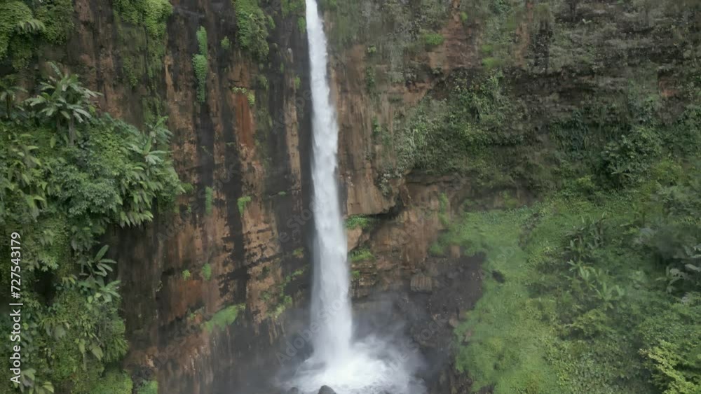 Aerial ascends cliff face high volume Kapas Biru waterfall in Java Aerial ascends cliff face high volume Kapas Biru waterfall in Java
