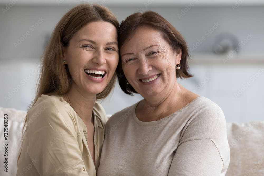 Happy senior mother and adult kid looking at camera, smiling, laughing, posing together, hugging with head touches, celebrating mothers day, enjoying affection, closeness, relation Happy senior mother and adult kid looking at camera, smiling, laughing, posing together, hugging with head touches, celebrating mothers day, enjoying affection, closeness, relation