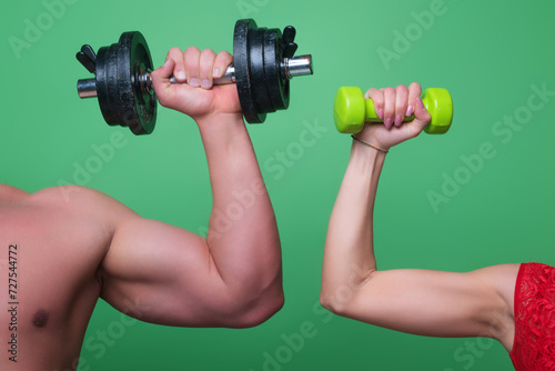 Male and female hands with dumbbells close-up. Training muscles. Female and male hand holds dumbbell. Muscular hands, exercises with dumbbells. Strong muscles. Dumbbell, studio. Fitness and Sport.