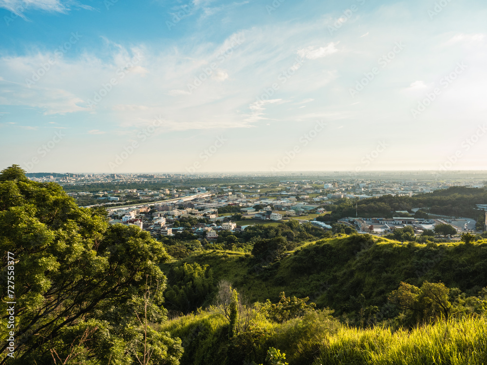 Obraz premium View of city from the beautiful mountain. Blue sky and green meadow.