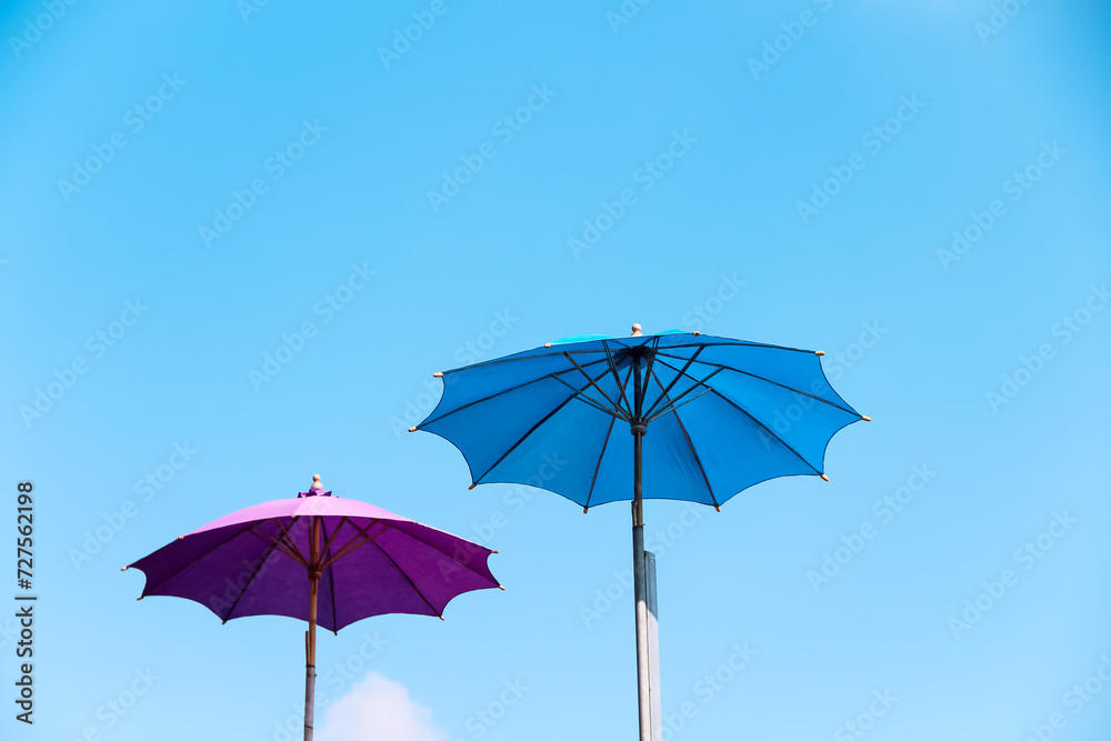 Two big umbrella on bright blue sky view outdoor summer background with space