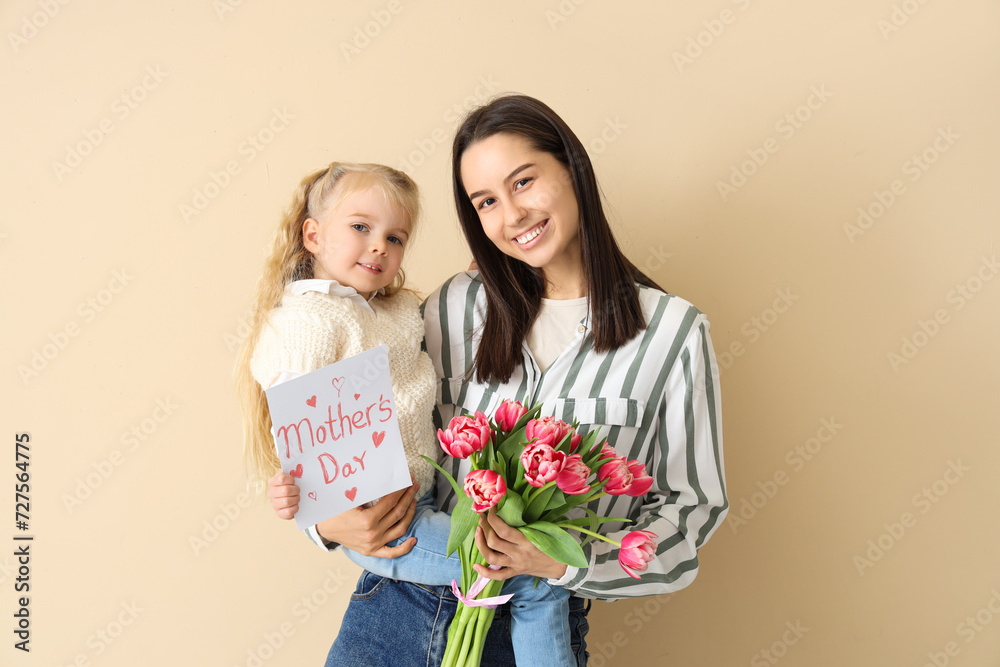 Little girl congratulating her happy mom with bouquet of flowers and greeting card on beige background. Mother's Day celebration Little girl congratulating her happy mom with bouquet of flowers and greeting card on beige background. Mother's Day celebration