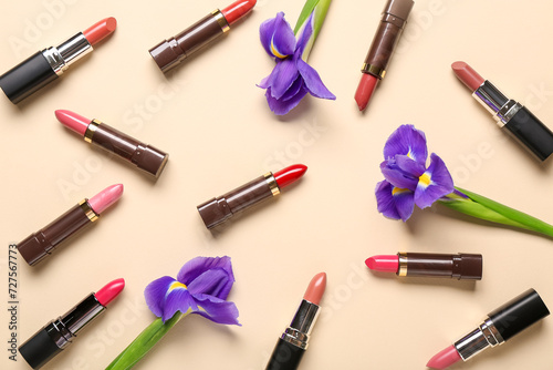 Lipsticks with flowers on beige background