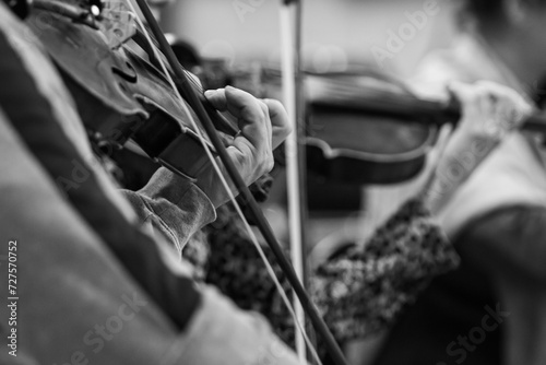  Hands of a musician playing the violin in an orchestra in black and white photo