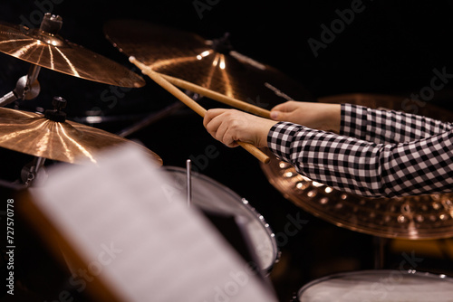 Hands of a girl playing a drum set