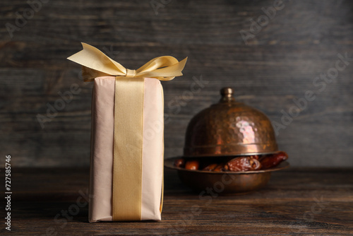 Gift box with dried dates for Ramadan on wooden table photo