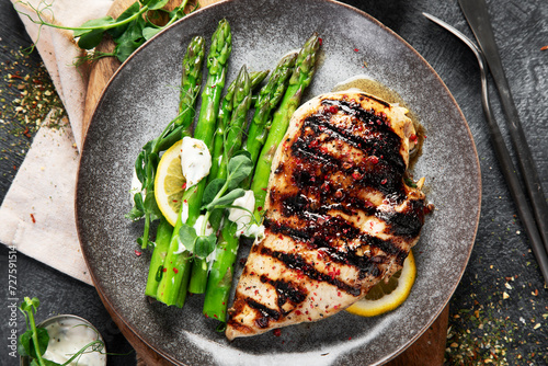 Tasty roast chicken breast, green asparagus and lemon.