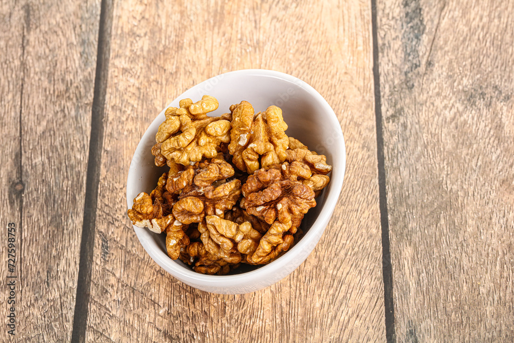 Cracked unshelled walnut in the bowl Cracked unshelled walnut in the bowl