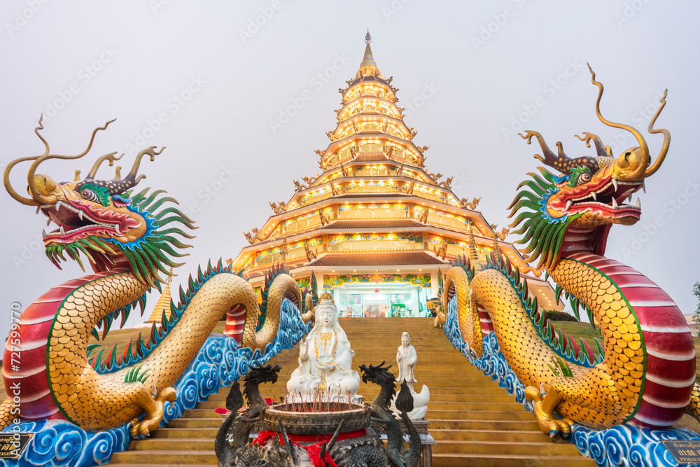 Fototapeta premium Nighttime at the Wat Huay Pla Kang temple complex,lit up,with Big Buddha towering beyond,Chiang Rai City,Thailand.
