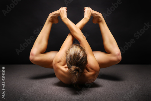 Abstract sport and medical concept. Beautiful body of yoga woman over dark background. photo