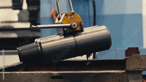 a worker grasps an iron billet with a crane. Folds them neatly.