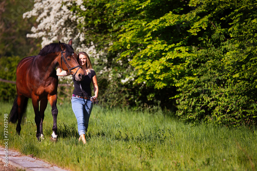 Young woman with horse in spring in nature.