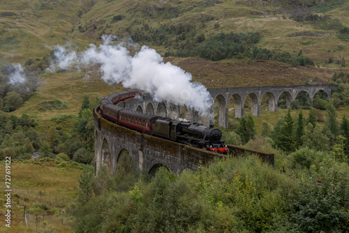 Steam train crosses the Glenfinnan viaduct in the Scottish Highlands. Famous landmark in Scotland. 