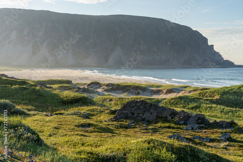 A serene summer evening by the Barents Sea. Beautiful and warm summer evening light on the shoreline and sandy beach, Finnmark, Norway. photo