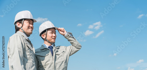 青空の中に立つ作業服を着た作業員（建設・建築・設計・不動産・土木・工事・現場監督・運送）
 photo