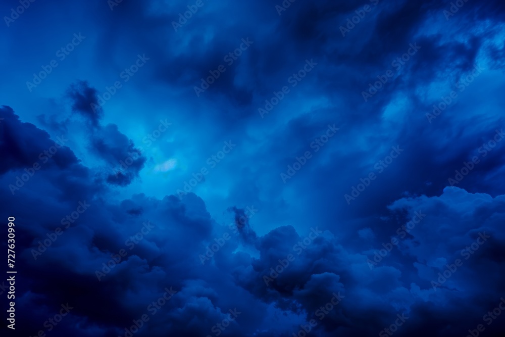 An evocative image showcasing the beauty and intensity of a deep blue sky filled with dramatic cloud formations. The play of light and shadow highlights the textures and depth, creating a sense of