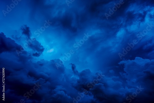 An evocative image showcasing the beauty and intensity of a deep blue sky filled with dramatic cloud formations. The play of light and shadow highlights the textures and depth, creating a sense of
