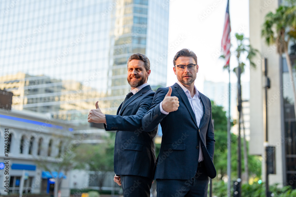 Business success men outdoor. Two business men on business meeting in city. Businessmen had a solid financial plan. Businessmen were supportive of their team. Successful business people. Business success men outdoor. Two business men on business meeting in city. Businessmen had a solid financial plan. Businessmen were supportive of their team. Successful business people.