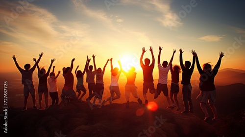 Silhouetted group of people jumping in front of bright sunrise over mountain peaks