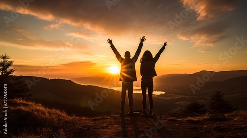 Smiling couple triumphantly celebrates their success on the majestic mountain peak © sorin