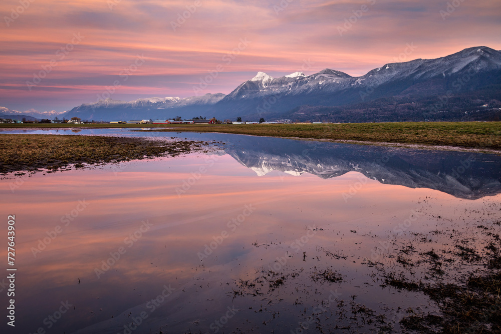Fototapeta premium Pink sky and reflection of snowy mount cheam in Chilliwack, Canada