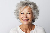 Confident senior woman with radiant smile on clean background. Ageing gracefully.