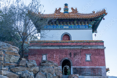 Ancient Chinese guard tower gate on top of the hill at the highest section of an ancient palace complex with two vertical sections and pale color combination of white and pink. photo